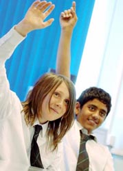 Two secondary school children with hands up
