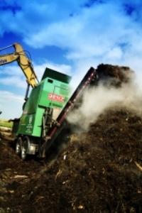 Big truck adds compost to a large pile