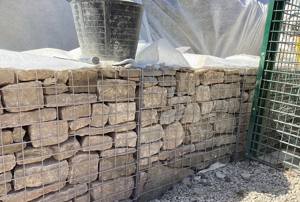 The gabions being built on site and filled with stone to strengthen the retaining wall