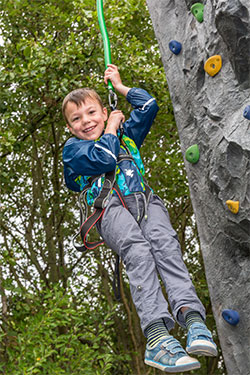 boy-wearing-a-harness-climbing-a-tree